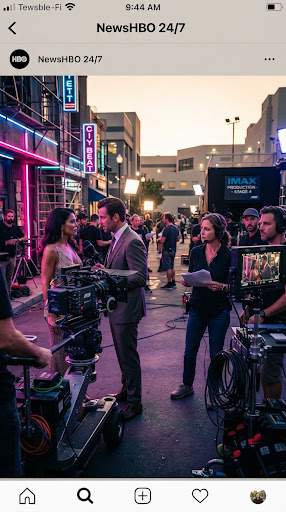 A film crew shooting on a studio backlot at golden hour